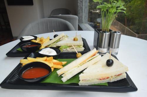 a black tray with a sandwich and chips and dips at Ginger Ahmedabad SG Road in Ahmedabad