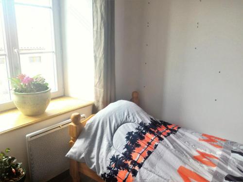 - une poupée assise sur un lit dans une chambre avec fenêtre dans l'établissement l'île au Trésor : Chambre, à Le Monastier sur Gazeille