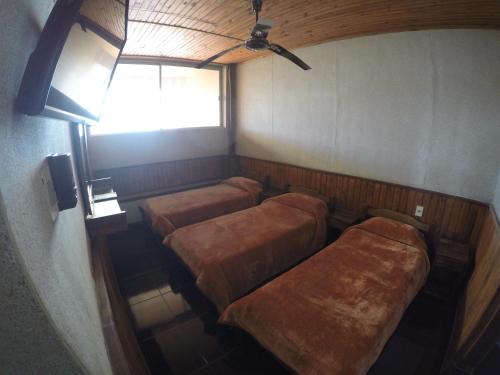 a small room with two beds and a window at Hotel Tia in Salto