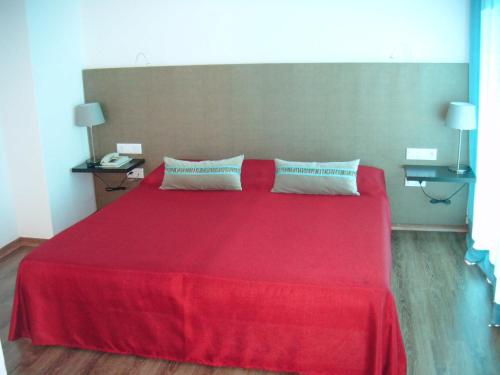 a bedroom with a red bed with two pillows at Hotel Alnacir in Faro