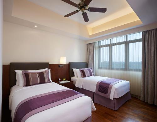 um quarto de hotel com 2 camas e uma ventoinha de tecto em Shangri-La Serviced Apartments, Yangon em Yangon