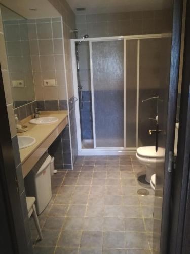 a bathroom with two sinks and a shower and a toilet at La Casina in Celorio