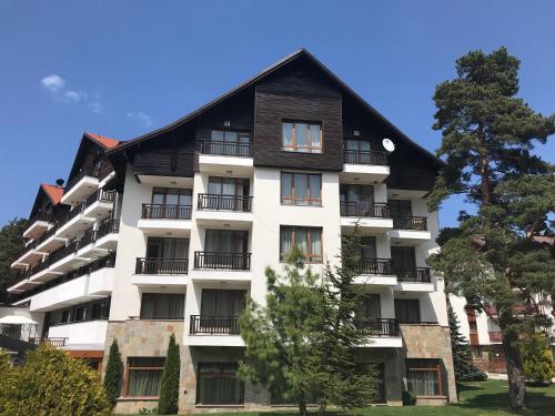 a white apartment building with a gambrel roof at Borovets Hills Ski & Spa - Half Board in Borovets