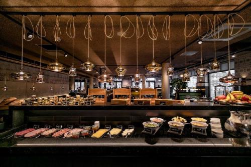 a buffet line with meat and other food items at Hotel Roermond Next Door in Roermond