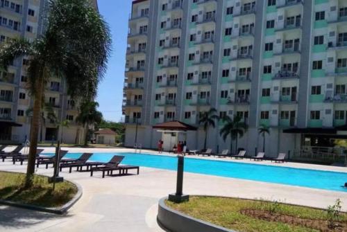 a large apartment building with a large swimming pool at Affordable condotel near Manila Airport in Manila