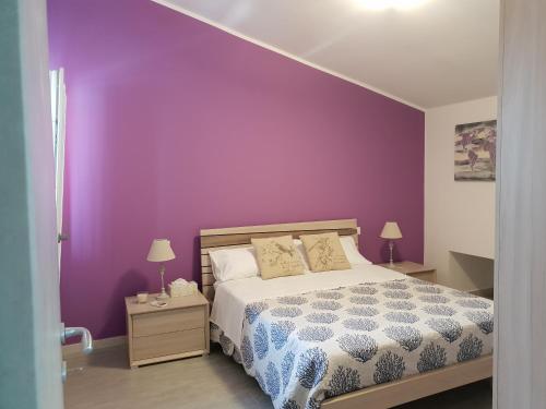 - une chambre avec un mur violet et un lit dans l'établissement Sea view, à Quartu SantʼElena