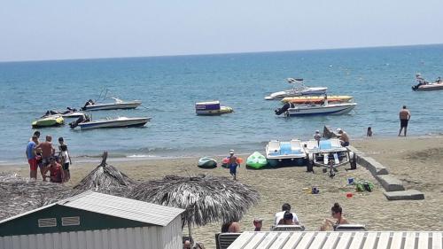 a group of people on a beach with boats in the water at Marina's Rooms in Larnaka