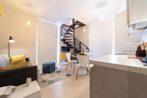 a kitchen and living room with a spiral staircase at Suite Cavour - SunTripSicily in Riposto