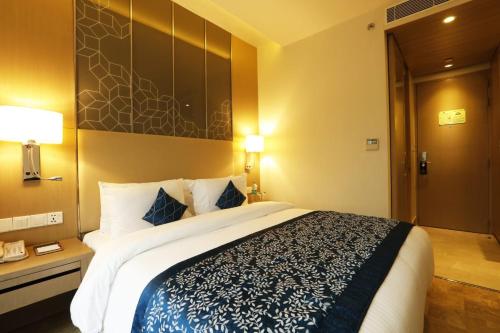 a bedroom with a large bed in a hotel room at Days Hotel Jaipur Tonk Road By Wyndham in Jaipur