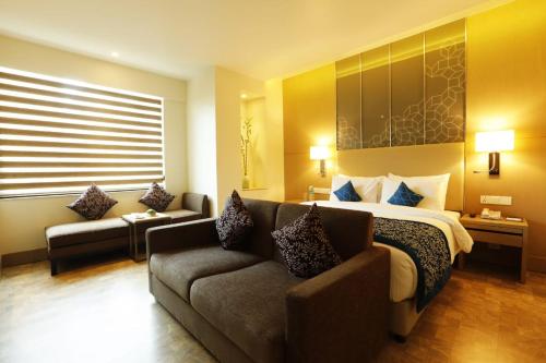 a hotel room with a bed and a couch at Days Hotel Jaipur Tonk Road By Wyndham in Jaipur