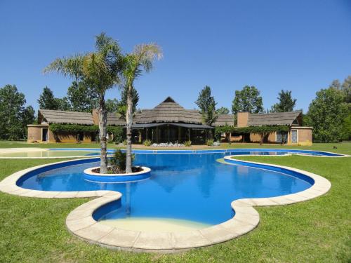 una piscina con una palmera frente a una casa en Solares de la Laguna en Santa Fe