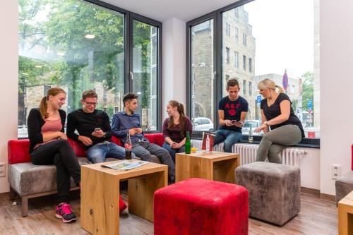 een groep mensen op banken in een kamer bij DJH Jugendgästehaus Adolph Kolping in Dortmund