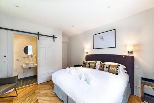 1 dormitorio con 1 cama blanca grande y 1 silla en Marie Paradis Apartment, en Chamonix-Mont-Blanc