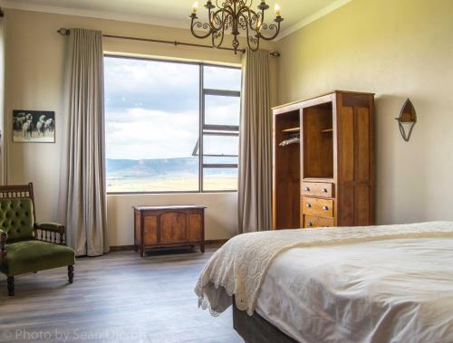 a bedroom with a bed and a large window at The Fat Mulberry Guest Farm in Fouriesburg