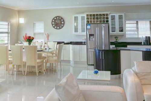 a kitchen and living room with a table and a refrigerator at JoJo's BnB in Mossel Bay
