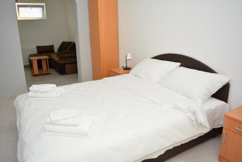 a bedroom with a large white bed with white pillows at Deltix Apartments in Vršac