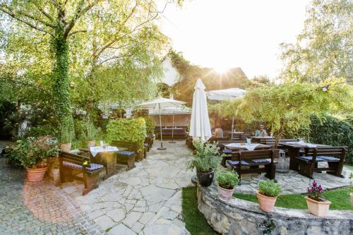 a patio with tables and chairs and an umbrella at Oleander Romantik Zimmer in Trausdorf