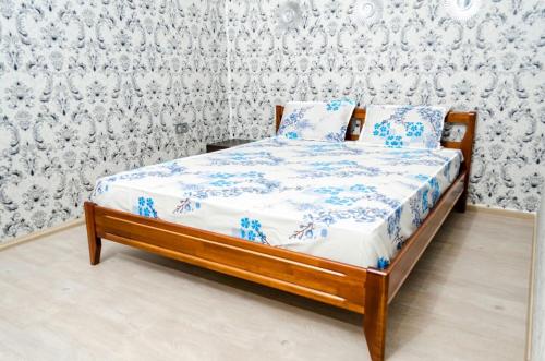a bed with blue and white sheets in a room at Admiral in Kharkiv