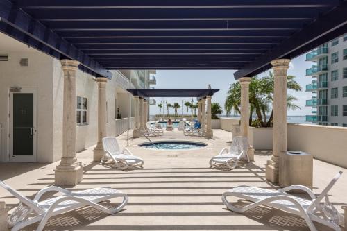 een patio met stoelen en een zwembad in een gebouw bij Miami Downtown Brickell Popular 4 BedRooms Bayview in Miami