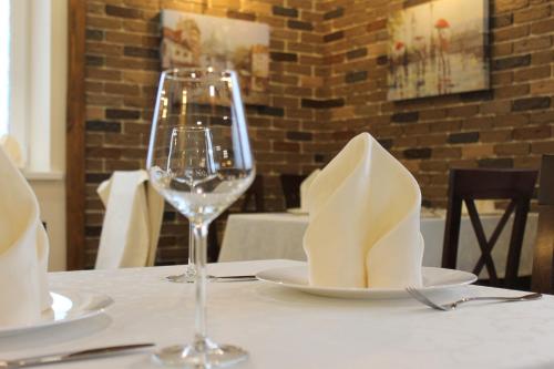 a table with a wine glass and a plate with a napkin at Три Сімки in Vyshhorod