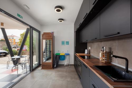 a kitchen with a sink and a large window at SUBTUB Hostel Makarska in Makarska
