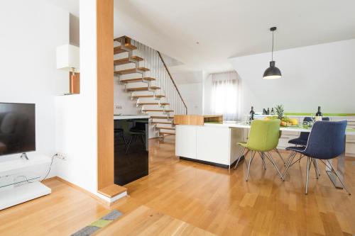 eine Küche und ein Wohnzimmer mit einem Esstisch und einer Treppe in der Unterkunft Hotel Graf Zeppelin in Konstanz