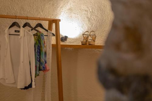 a closet with a rack of clothes and shoes at Nalas Suites in Emporio Santorini