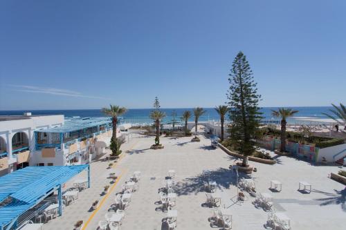 an aerial view of a beach with chairs and palm trees at El Mouradi Club Selima in Port El Kantaoui