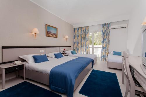 una camera d'albergo con due letti e una televisione di El Mouradi Club Selima a Port El Kantaoui