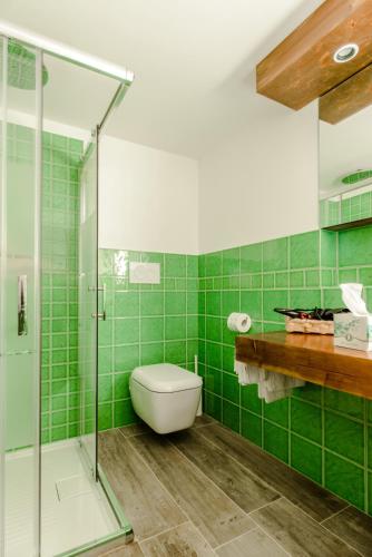 a green tiled bathroom with a toilet and a glass shower at Villa Rosa di Nonna Rosa in Vico Equense