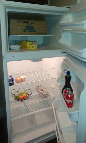 d'un réfrigérateur ouvert avec une bouteille de coke. dans l'établissement Spacious Frontier Park Apartment, à Érié