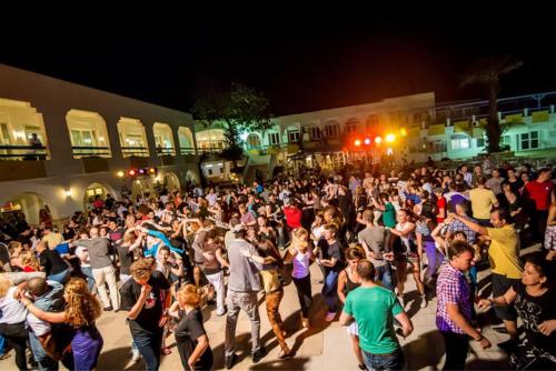 a crowd of people walking down a street at night at El Mouradi Club Selima in Port El Kantaoui
