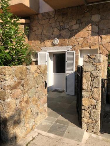 an entrance to a stone building with a white door at L'Acqua Viva in Calacuccia