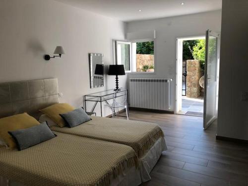 a bedroom with a bed and a door to a patio at L'Acqua Viva in Calacuccia