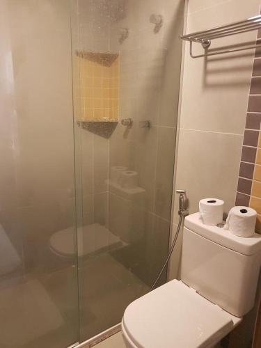 a bathroom with a toilet and a glass shower at Flat Olímpia Park Resort in Olímpia