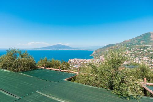 a tennis court on a hill with a view of the water at Villa Rosa di Nonna Rosa in Vico Equense