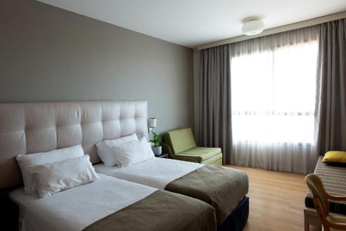 Ein Bett oder Betten in einem Zimmer der Unterkunft Shefayim Kibbutz Hotel