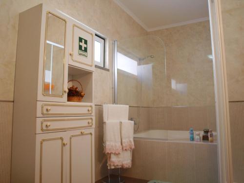 uma casa de banho com um chuveiro, uma banheira e um lavatório. em Chalé Chafaris D'el Rei em Elvas