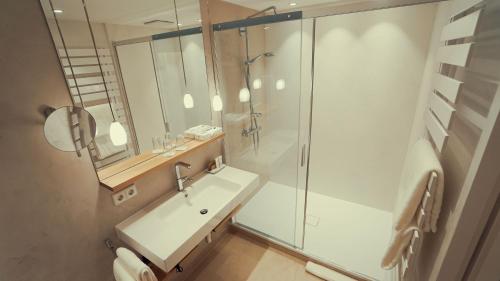 a bathroom with a glass shower and a sink at Hotel Adler Asperg in Asperg