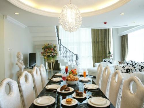 a dining room with a table and chairs with food on it at LK Legend in Pattaya