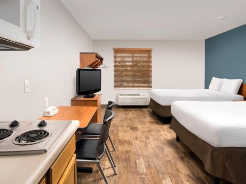 a hotel room with two beds and a kitchen with a stove at WoodSpring Suites Allentown Bethlehem in Bethlehem