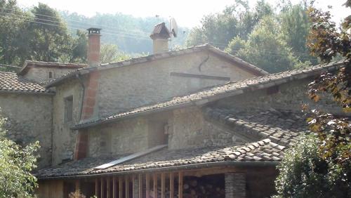 una casa in pietra con due camini sopra di L'abondance a La Baume-Cornillane