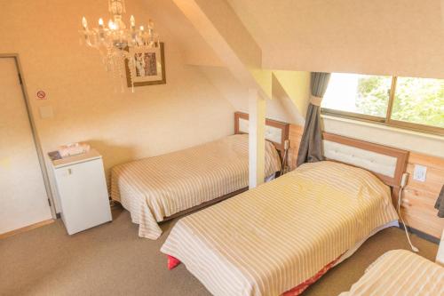 a room with two beds and a chandelier at Nikko Park Lodge Mountain Side in Nikko