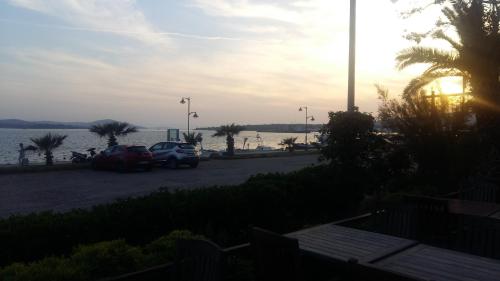 two cars parked in a parking lot next to the water at Aliye Hanim Hotel in Ayvalık