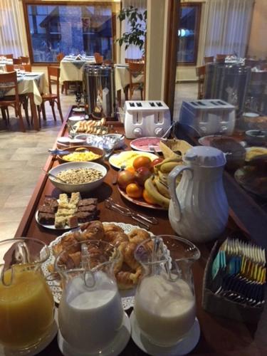 a table topped with plates of food and glasses of milk at Ayelen Andina in Esquel