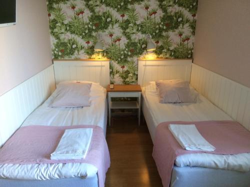 a room with two beds and a table with lights at Hotell Paradis in Eksjö
