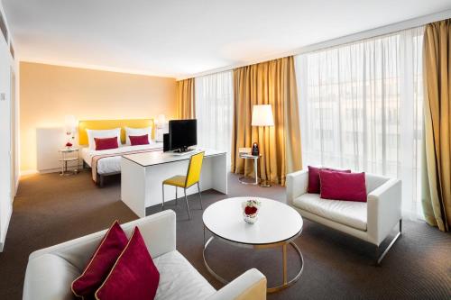 a hotel room with a bed and a living room at Vienna House by Wyndham Andel's Prague in Prague