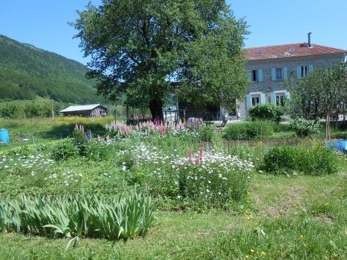 um campo de flores em frente a uma casa em Gîtes des Gabriels em La Chapelle-en-Vercors