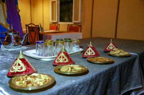 a table with plates of food on a table at Sahara Desert Luxury Camp in Merzouga