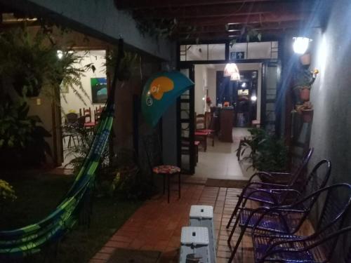 een patio met een glijbaan en stoelen voor een gebouw bij Pousada Dom Aquino in Campo Grande